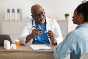 Experienced black doctor explaining treatment plan to patient